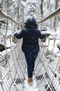 Rear view of person on snow covered tree