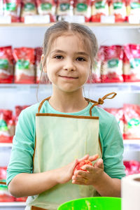 Baking concept. a little girl in an apron prepares and sculpts cookies.