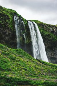 Scenic view of waterfall against sky