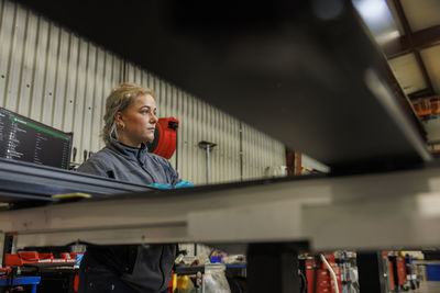 Young female industrial worker working in factory