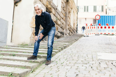 Full length portrait of smiling man in city