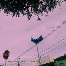 Low angle view of road sign against sky during sunset