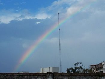 Low angle view of rainbow over cloudy sky