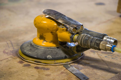 Yellow sander close-up on the table, dirty sander