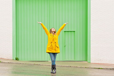 Full length of woman standing against wall