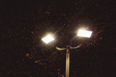 Low angle view of illuminated lights against sky at night