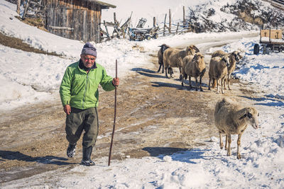 Man standing on snow covered landscape during winter