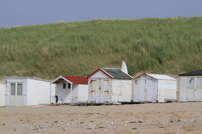 Beach hut on field against sky