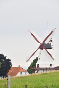 Traditional windmill on field against sky