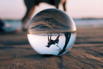 Close-up of crystal ball on beach