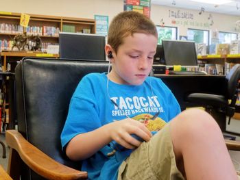 Boy looking at while sitting on seat