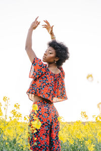 Full length of girl standing on field against sky