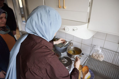 Woman in headscarf cooking for eid al-fitr at home