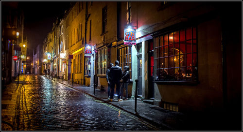 Man walking on illuminated street at night