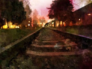 Railroad tracks in city at night