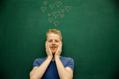 Portrait of young man with arms in background