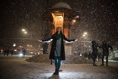 Full length of woman at illuminated park during winter