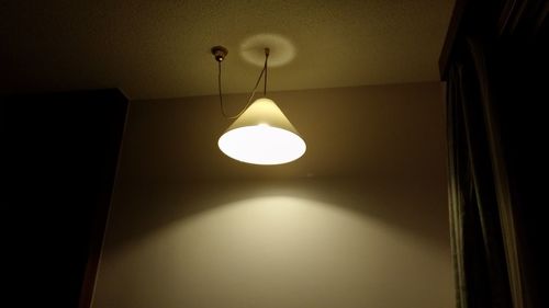 Low angle view of illuminated light bulb hanging