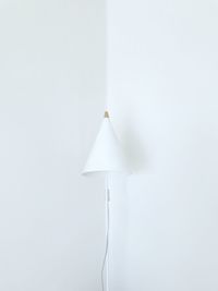 Close-up of electric lamp against white wall