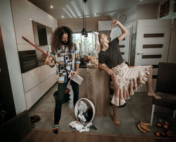 Woman singing while man holding equipment at home