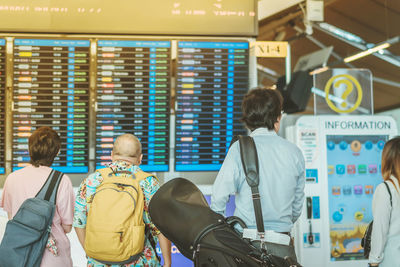 Rear view of people standing at airport