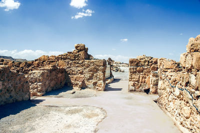 Stone walls at masada against blue sky