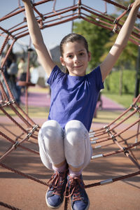 Portrait of smiling girl playing on jungle gym 