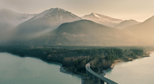 Scenic view of river by mountains against sky during winter