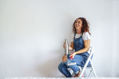 Young woman sitting on wall