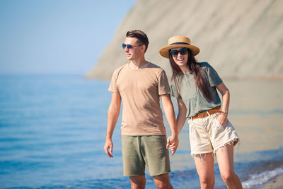 Portrait of smiling couple standing at beach