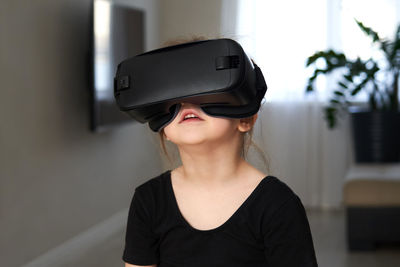 Girl wearing virtual reality simulator at home