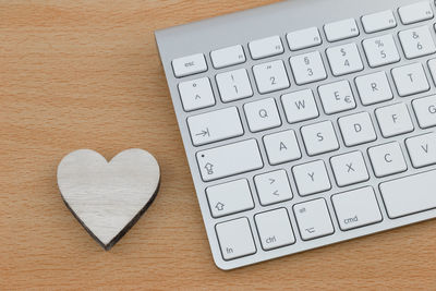 High angle view of heart shape with keyboard on wooden table