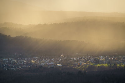 The low sun casts long shadows over bad rotenfels in the black forest during an upcoming rain shower