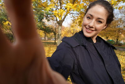 Portrait of smiling young woman with autumn leaves