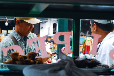 People sitting at market stall