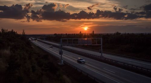 High angle view of cars on highway against sky during sunset