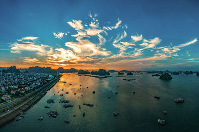 Aerial view of sea against blue sky during sunset