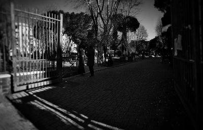 Man walking on footpath by street in city