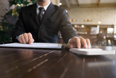 Midsection of man working on table