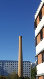 Low angle view of buildings against clear blue sky