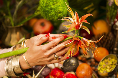 Midsection of woman holding strawberry plant