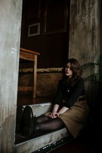 Portrait of young woman sitting on floor