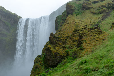 Scenic view of skogafoss waterfall with rocks in the foreground 