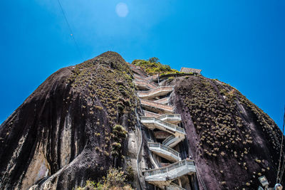 Low angle view of abandoned built structure against blue sky