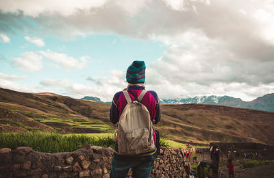 Rear view of woman standing on landscape against mountain