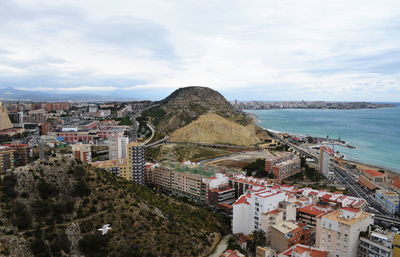 High angle view of townscape by sea against sky