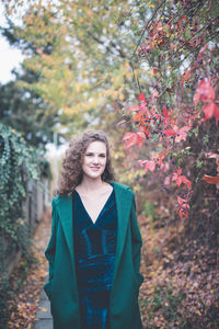 Beautiful girl in a green coat in an autumn park