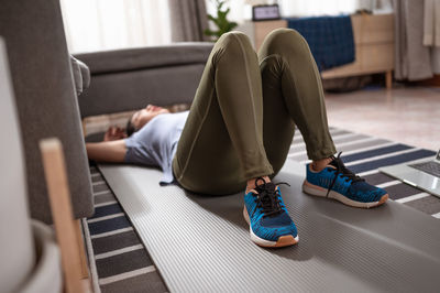 Low section of man sitting on seat at home