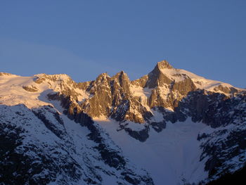 Scenic view of snowcapped mountains against clear blue sky