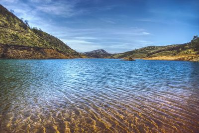 Scenic view of lake against cloudy sky